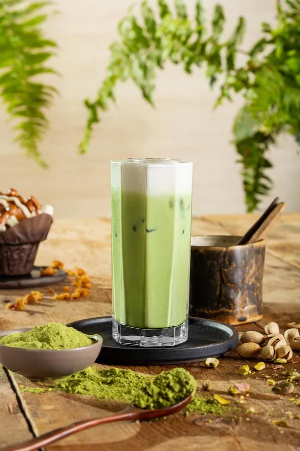 Layered coffee and matcha drinks styled on a cafe table